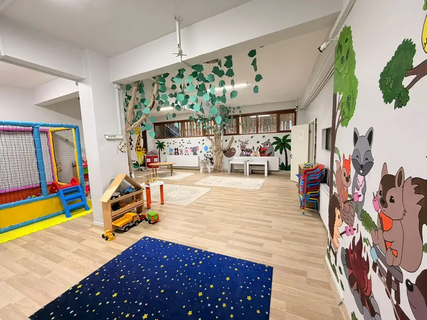 Yıldız desenli halısı ve orman temalı duvar resimleriyle geniş oyun salonu